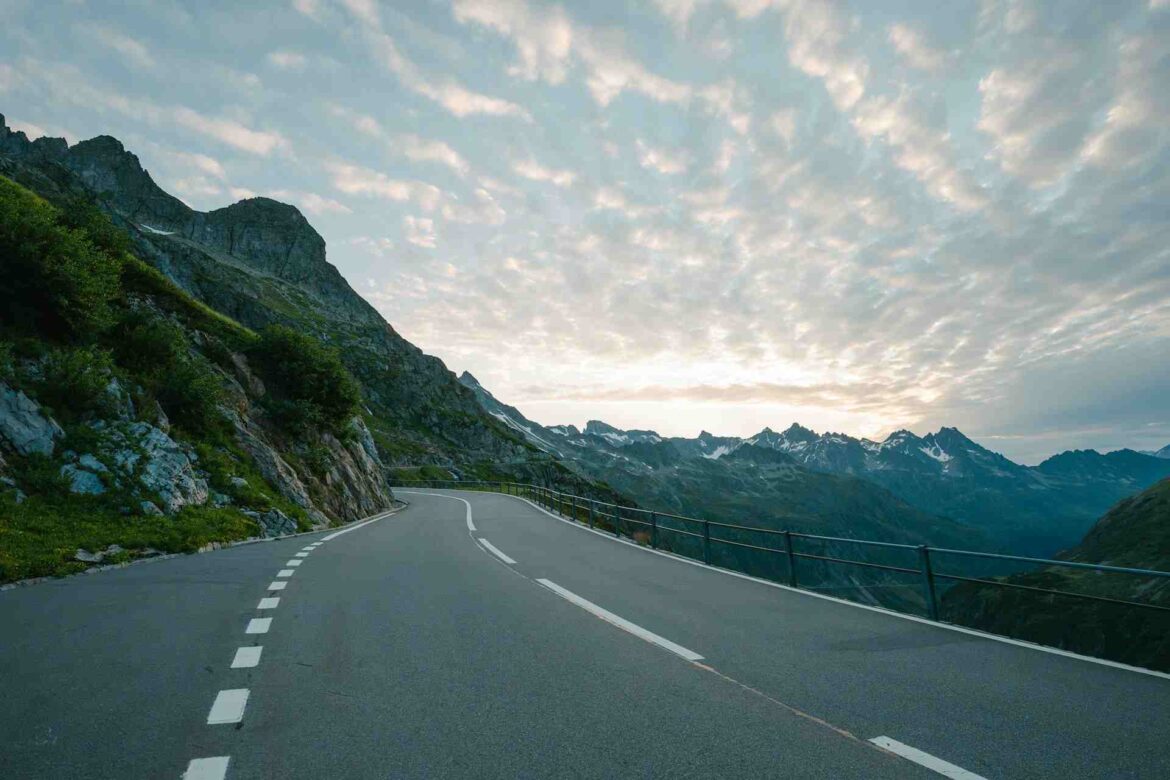 Une route sinueuse de montagne offre un paysage spectaculaire pour un road trip inoubliable.